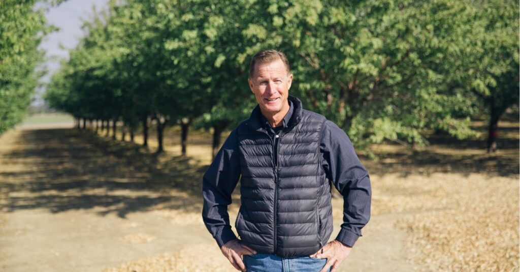 Frank Muller standing in an orchard.