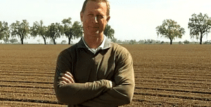 A man standing in Frank's field with his arms crossed.