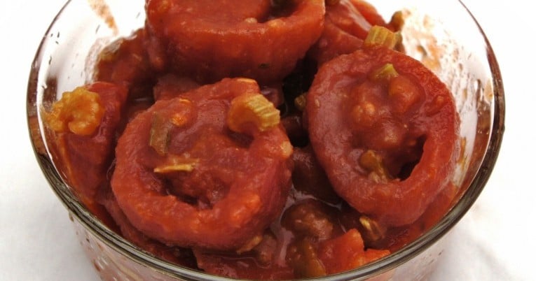 A fancy glass jar with Mexican stewed tomatoes and onions.