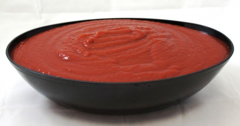 A bowl of #10 Fancy Tomato Ketchup on a white surface.