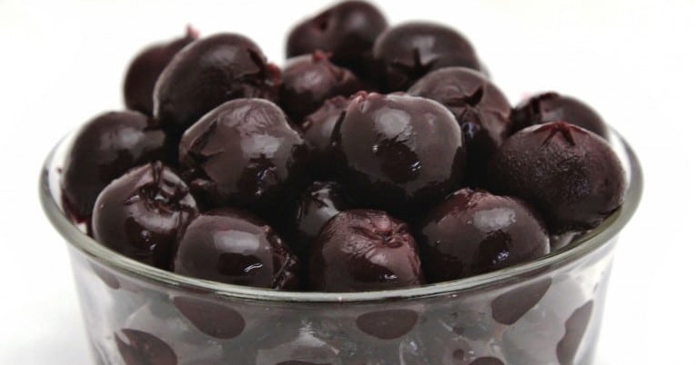 Black olives in a glass bowl.
