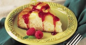 A Pear-Lemon Cake with Raspberry Drizzle on a plate.