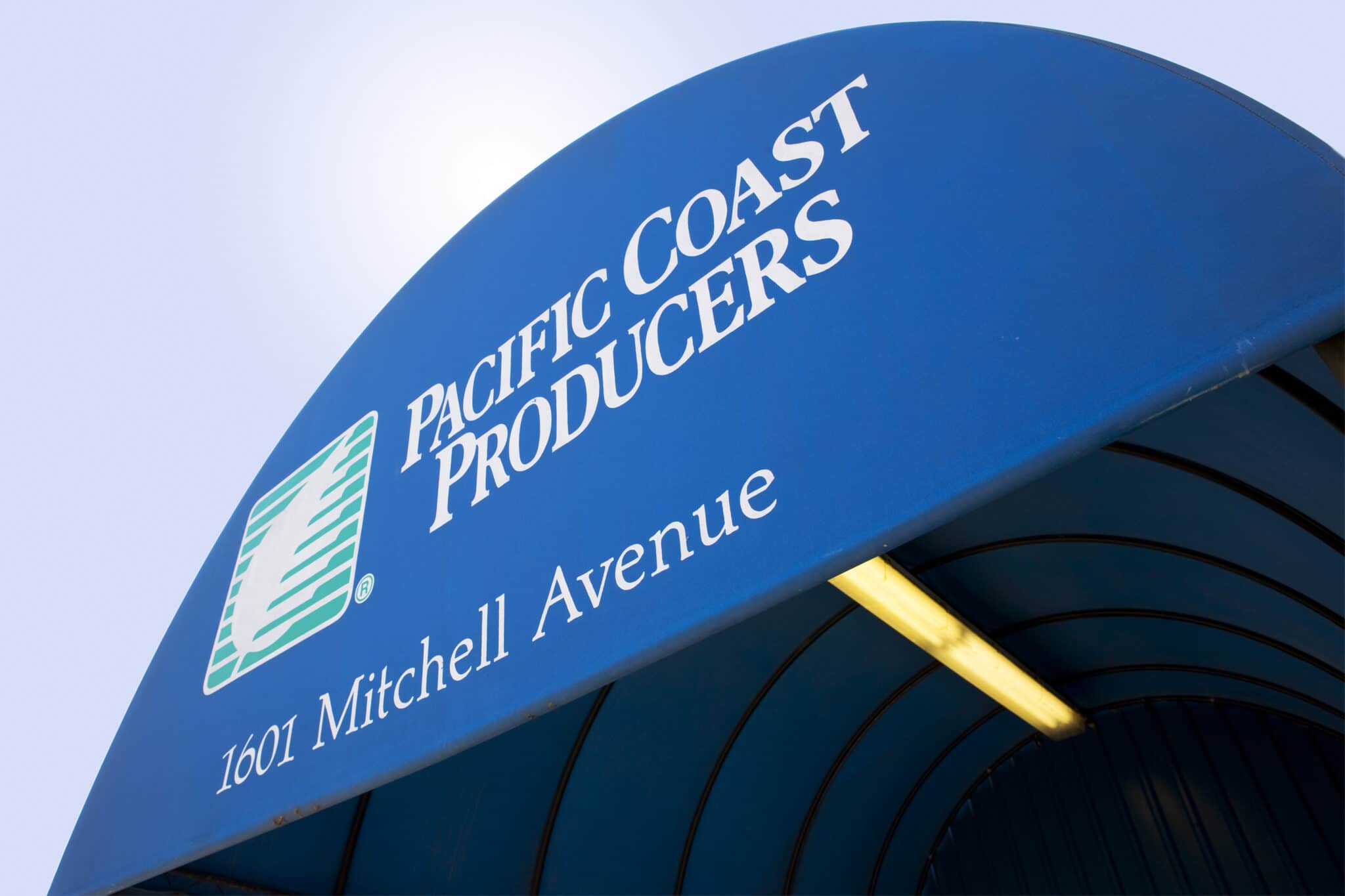 A blue sign that says Pacific Coast Producers at the Oroville plant.