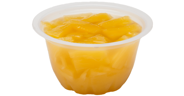 A cup of orange juice with pineapple tidbits in real fruit juice on a white background.