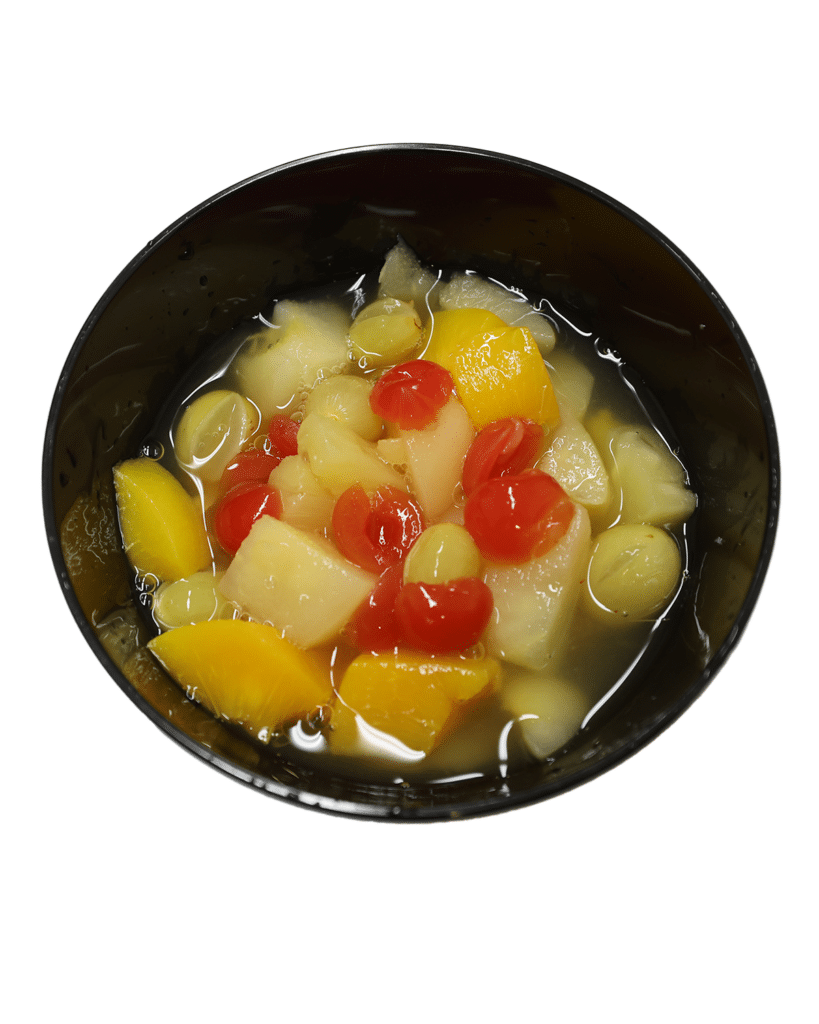 A bowl of mixed fruit and vegetables in a black bowl.