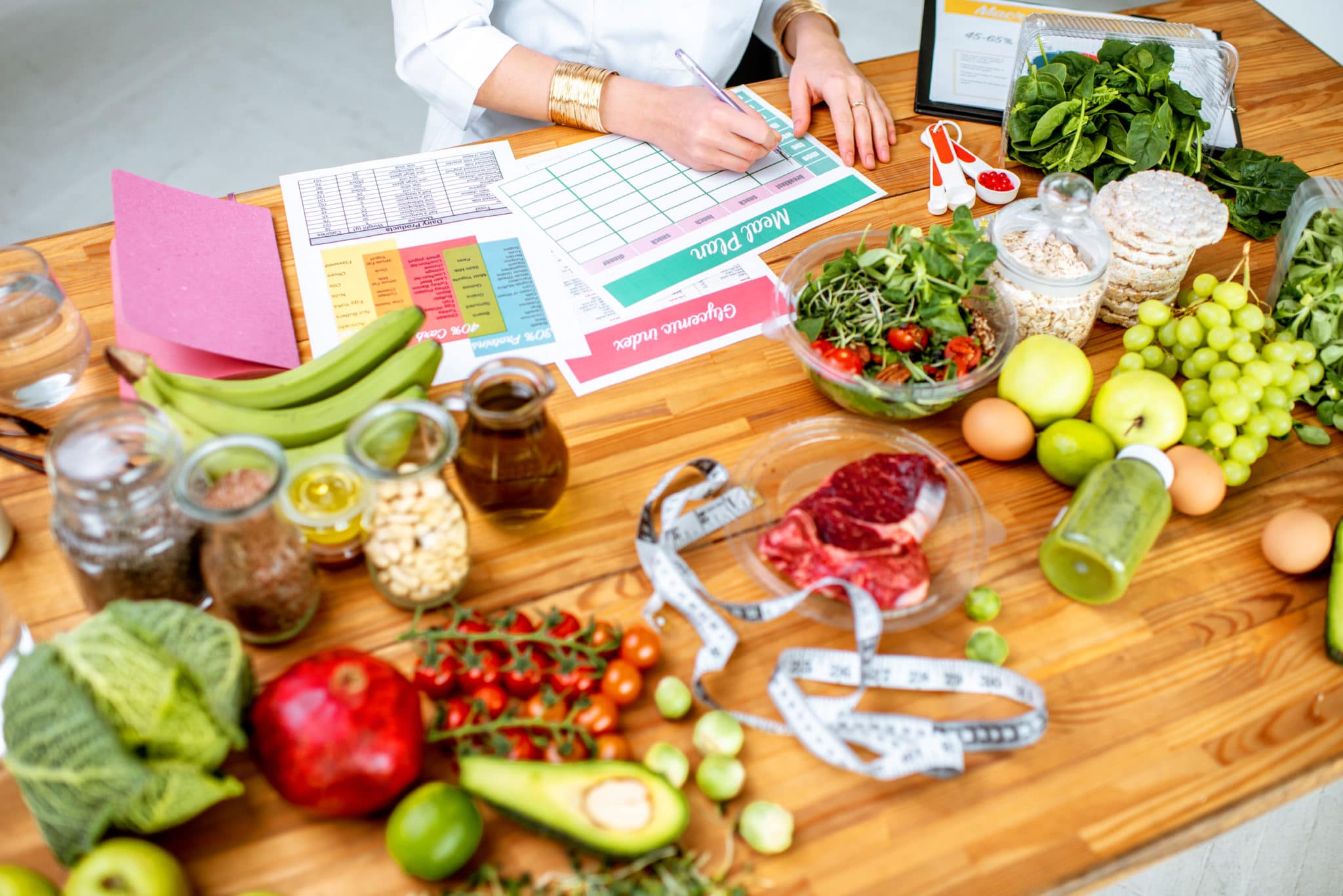 A woman consults with nutrition professionals at a table surrounded by fruits and vegetables.
