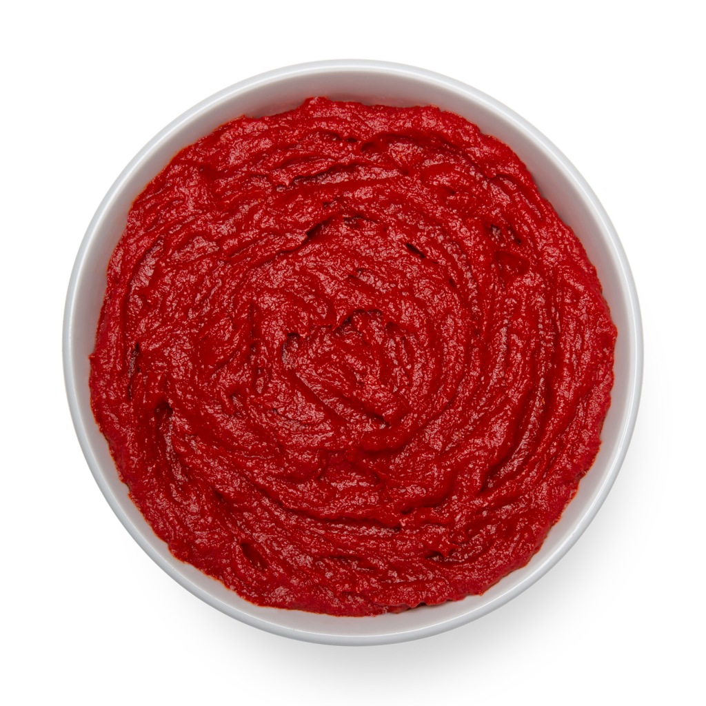 A bowl of red sauce on a black background.