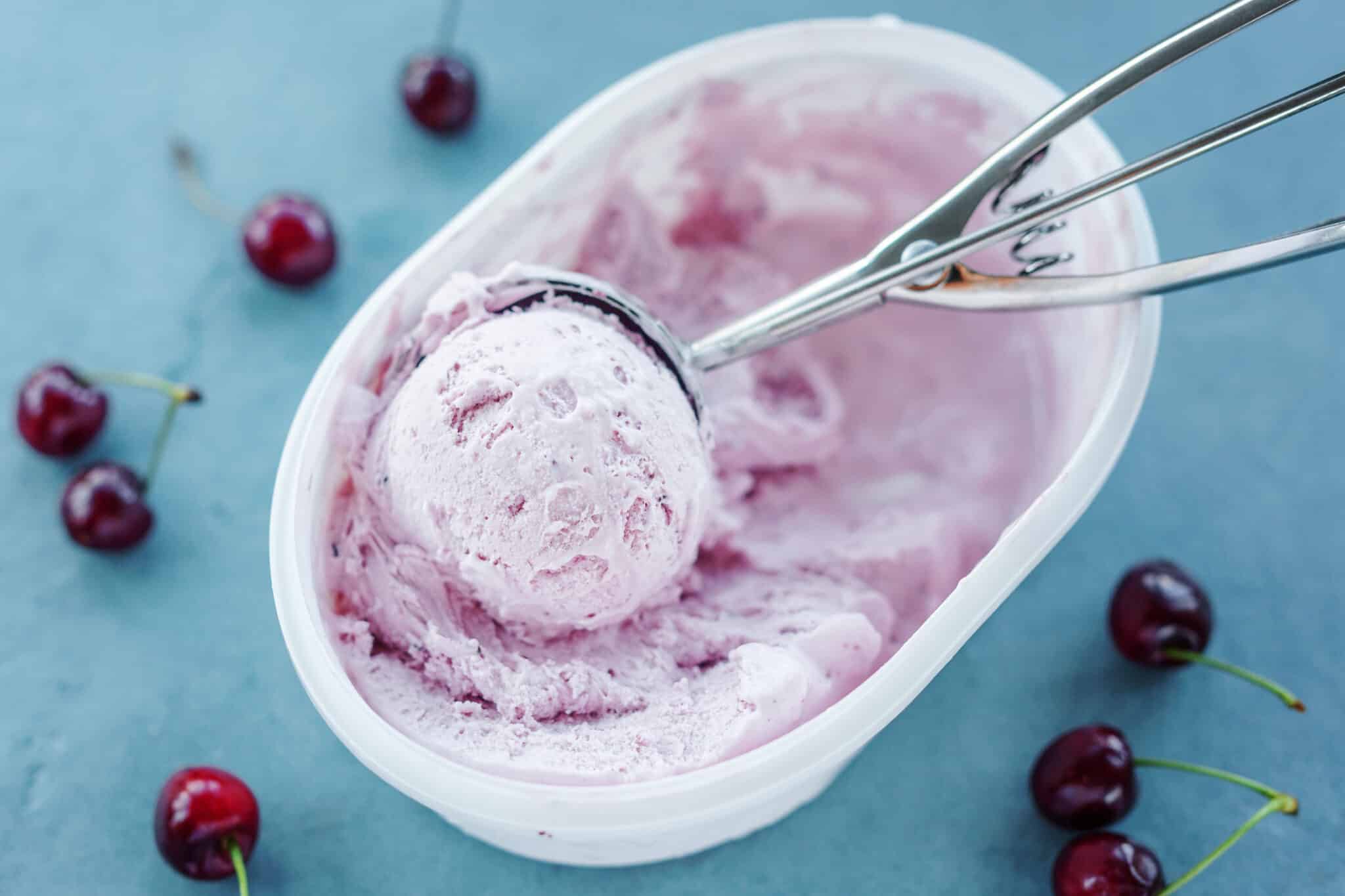 A bowl of ice cream with cherries in it.