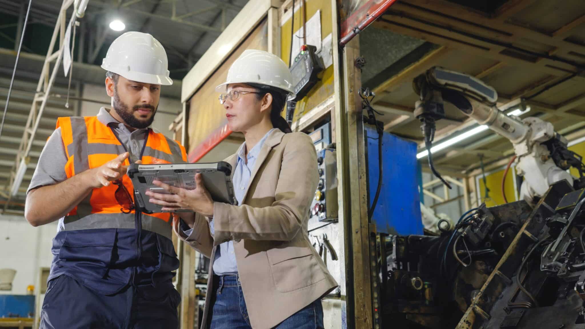 Industrial workers looking at a portable screen at work
